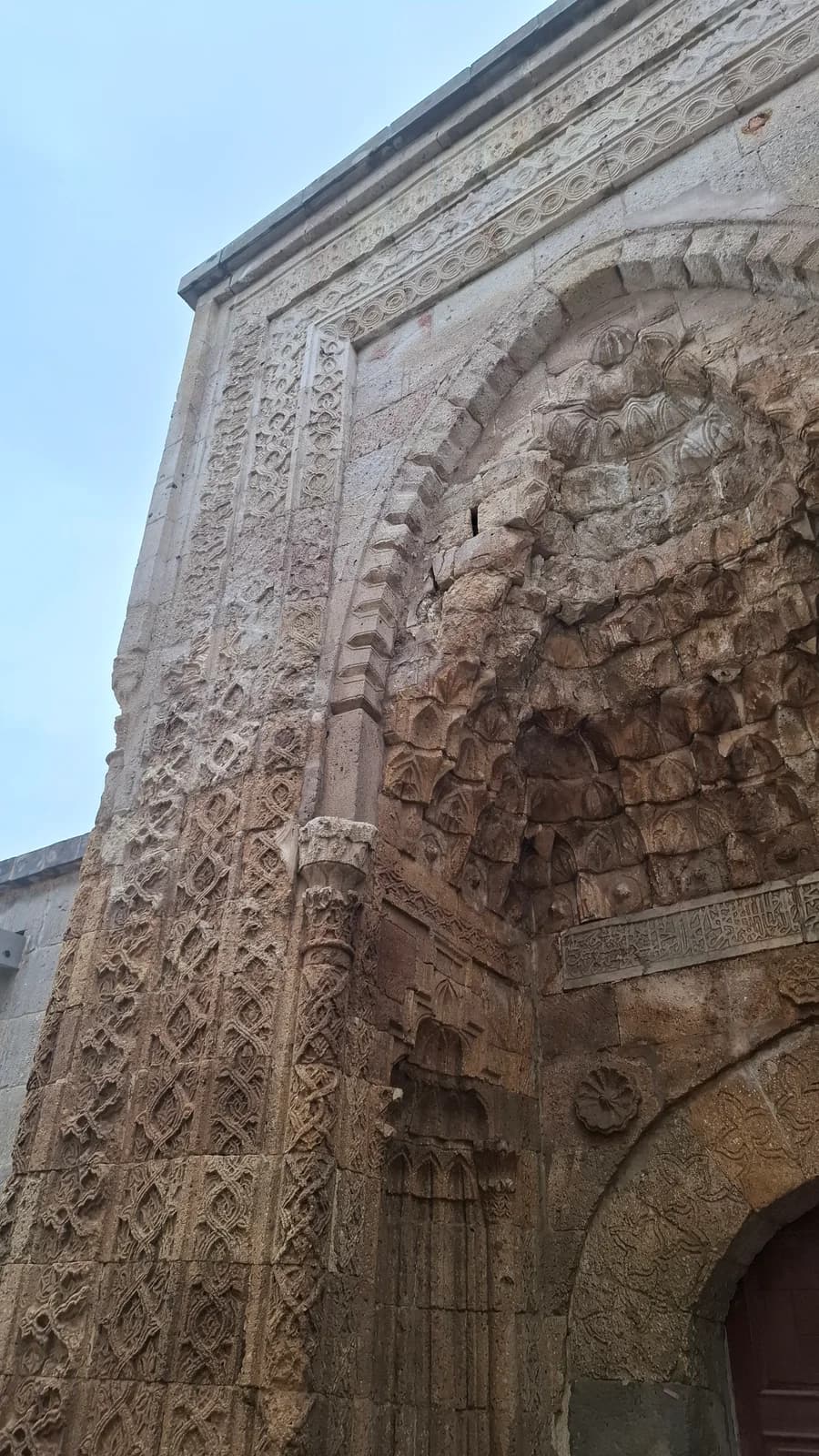 Carved stone surround and muqarnas detail on the portal of İsmail Ağa Medresesi.