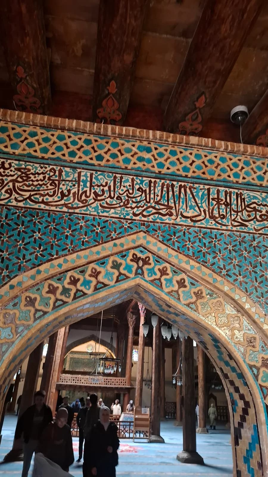 قوس من الفسيفساء الخزفية يفتح على قاعة الصلاة الخشبية في جامع أشرف أوغلو.