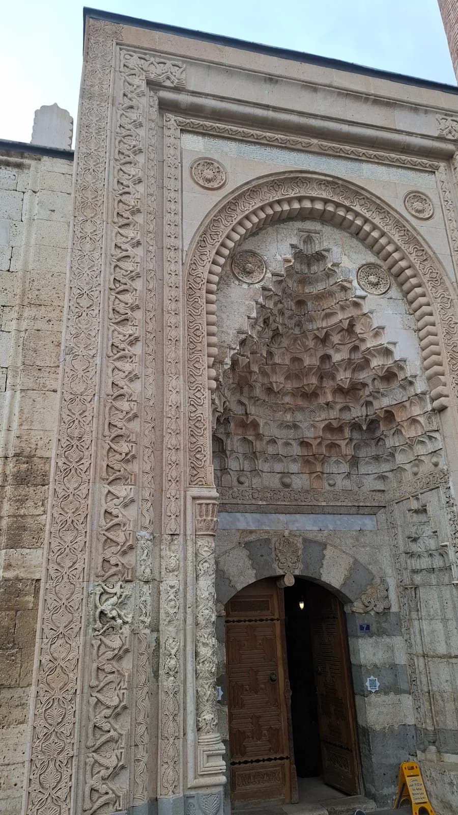 Eşrefoğlu Camii taç kapısında mukarnas ve bitkisel taş bezeme.